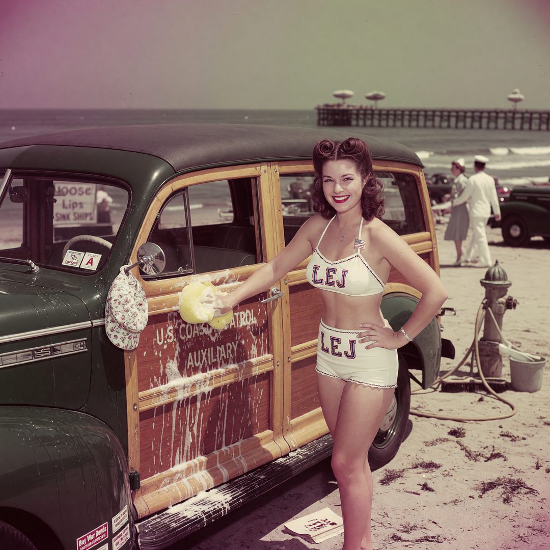 An LEJ girl washing a wood-panel woody wagon by the sea, 1940.